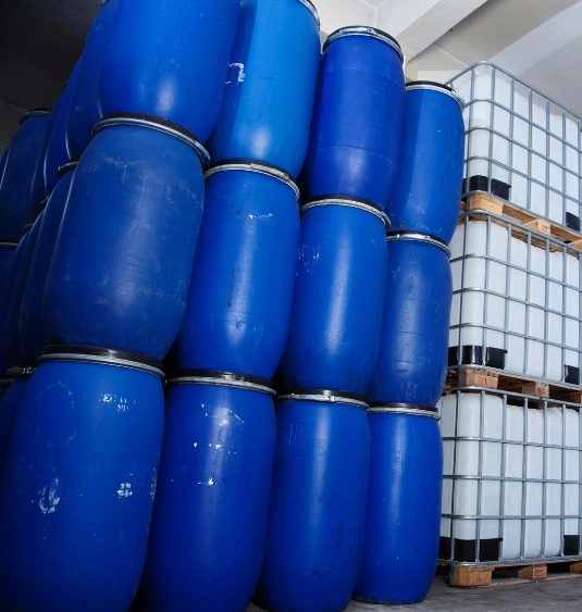 Chemical export packaging showing sealed HDPE drums and palletized IBC containers