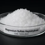 Magnesium Sulfate Heptahydrate; Epsom Salt; MgSO₄·7H₂O, CAS 10034-99-8 white crystals in a petri dish